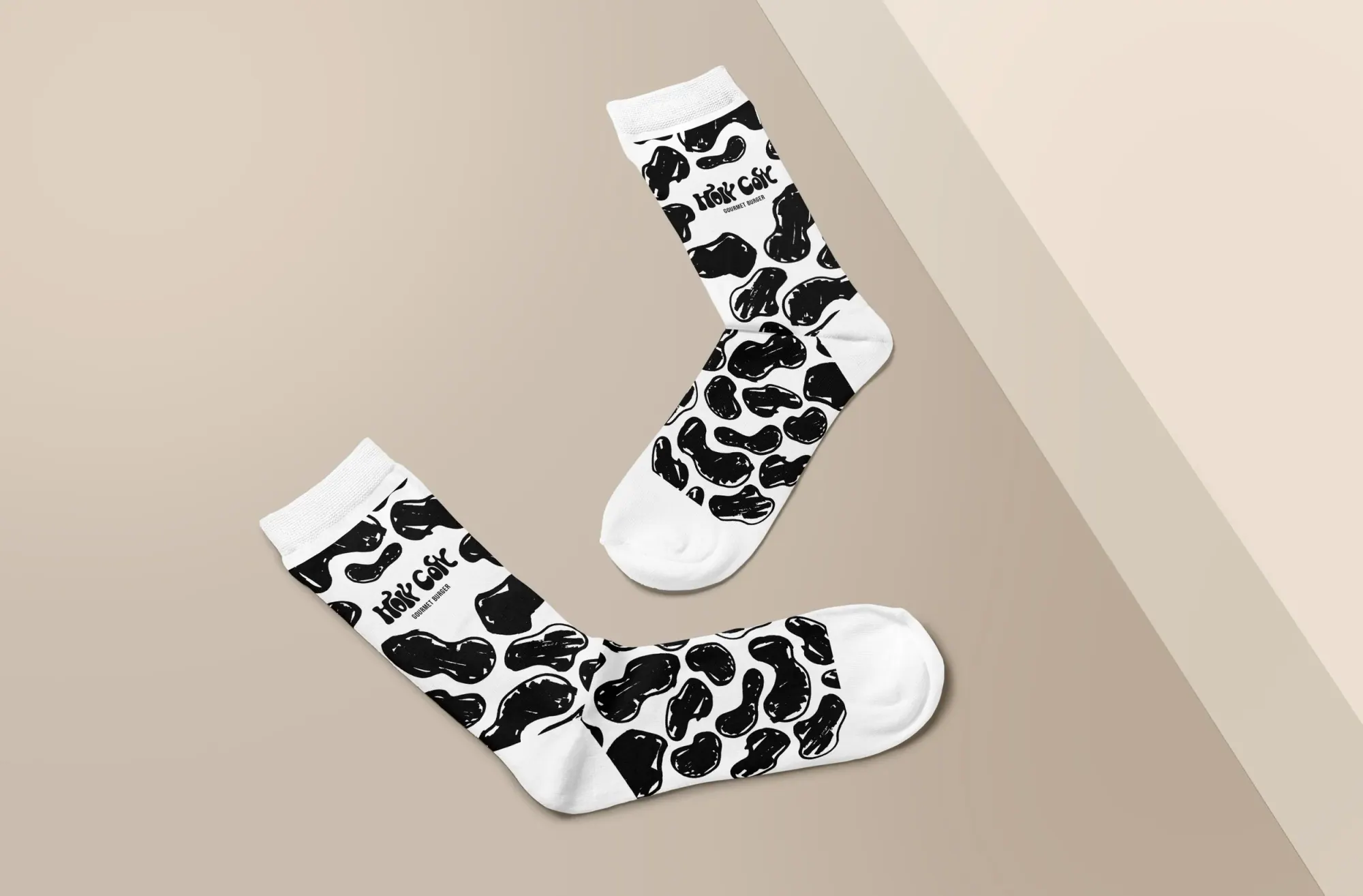 Une paire de chaussettes blanches avec un motif noir de haricots et le texte 'Hok Coc'.