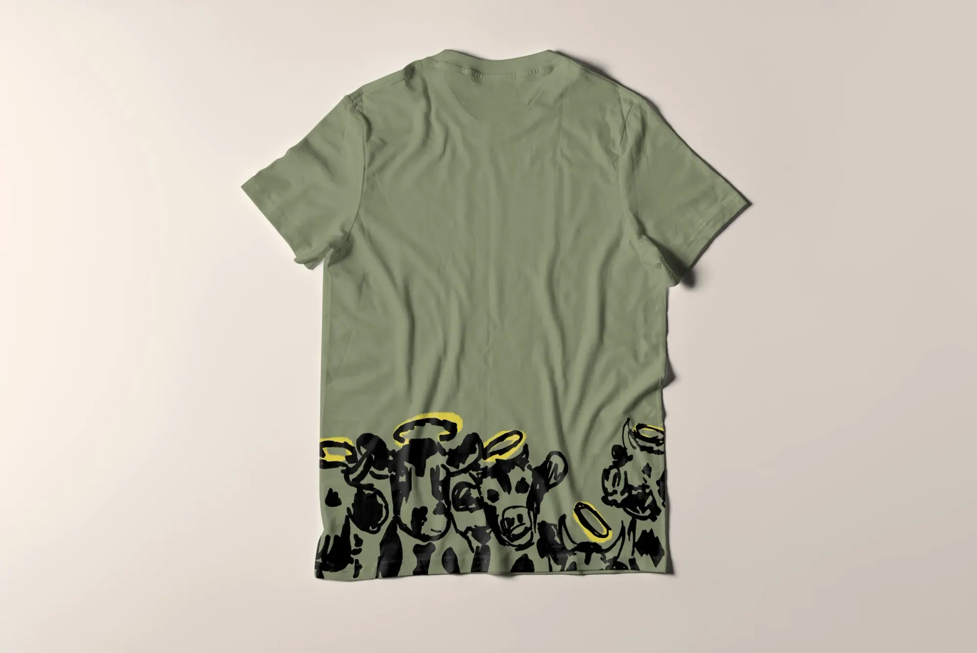 T-shirt vert avec un graphique de vaches noires et blanches portant des halos dorés à la base